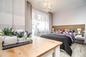 a bedroom with a bed and a table with flowers at Willa Anavill in Mielno