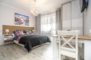 a bedroom with a bed and a desk and a window at Willa Anavill in Mielno