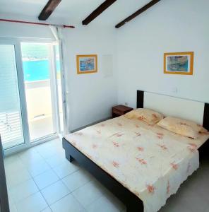 1 dormitorio con 1 cama y vistas al océano en Rab Island Apartments Del Sole, en Supetarska Draga