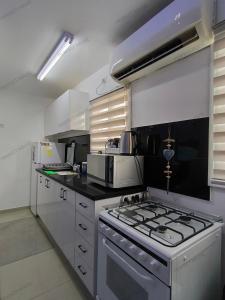 uma cozinha com uma placa de fogão e forno. em Perfect House em Eilat