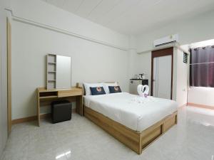 Ban Bang KhanRoomQuest SPS Hotel and Residence的一间卧室，配有一张床、一张书桌和一扇窗户