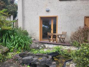 un patio con mesa y sillas en un jardín en Apartamento El Olivo, en Vigo