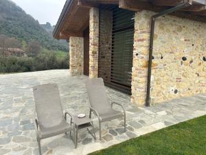 two chairs and a table on a stone patio at Nuovo B&B Colline San Benedetto in Marostica