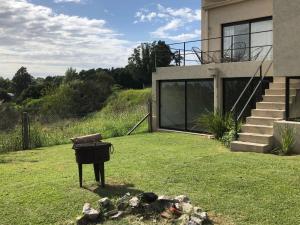 a grill in a yard in front of a house at Casa EL ORIGEN in Tandil