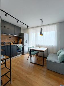 uma cozinha e uma sala de estar com uma mesa e um sofá em Кокетен апартамент VeRa Suite em Silistra
