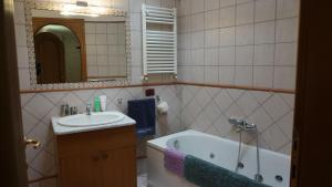 uma casa de banho com um lavatório, uma banheira e um espelho. em Pigneto liberty house em Roma