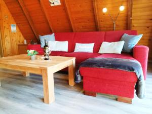 un sofá rojo y una mesa de centro en una habitación en Ferienhaus Seestern, en Carolinensiel
