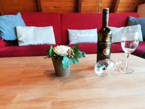 una botella de vino y una flor en una mesa con una copa en Ferienhaus Seestern, en Carolinensiel