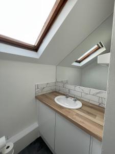a bathroom with a sink and a skylight at 1 Fitzhamon Embankment APARTMENTS opposite Principality Stadium - free parking nearby - LONG STAY OFFER - newly redecorated March 2024 in Cardiff
