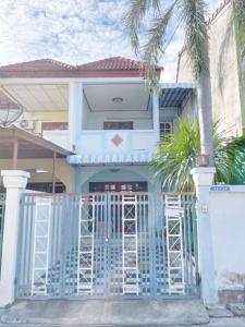 a blue house with a gate and palm trees at Bang Saen House: Friends/Family. in Ban Thai Don (1)