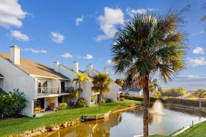a house next to a river with a palm tree at Seawinds Oceanfront Condo in St. Augustine