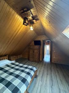 Ce lit se trouve dans une chambre en bois dotée d'un plafond. dans l'établissement Писанка, à Yaremtche