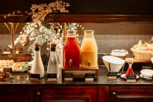 - un comptoir avec plusieurs bouteilles de jus et de boissons dans l'établissement Hôtel Dali Val d'Europe, à Chanteloup-en-Brie