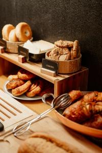 - une table avec 3 étagères de pain et de viennoiseries dans l'établissement Hôtel Dali Val d'Europe, à Chanteloup-en-Brie