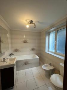 a bathroom with a tub and a toilet and a sink at Писанка in Yaremche