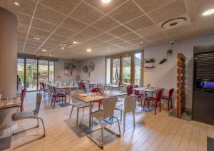 - une salle à manger avec des tables, des chaises et des fenêtres dans l'établissement Campanile Aix-en-Provence Sud - Pont de l'Arc, à Aix-en-Provence