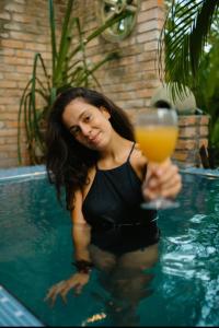 a woman in a swimming pool holding a glass of orange juice at Airport Villa Kamatha -Foreign booking only in Katunayake