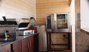 a kitchen with a microwave and a refrigerator at Zeyman’s Appartments in Kigali
