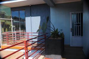 a balcony of a building with a door and a plant at Zeyman’s Appartments in Kigali