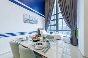 a dining room with a table and a large window at Ekocheras Cozy Loft in Kuala Lumpur