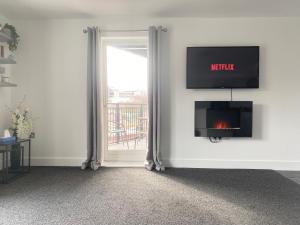 sala de estar con chimenea y ventana en Luxury Apartment with Balcony en Dewsbury