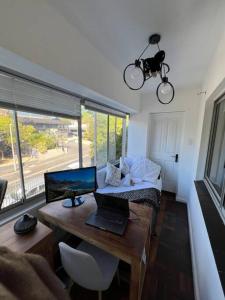 a room with a desk with a laptop and a bed at Sea Point at Princeton Place in Cape Town