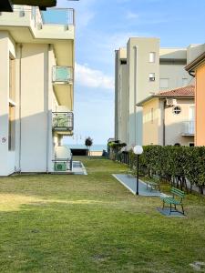 a row of buildings with benches in the grass at Jesolo Sun Beach House - Host Solution in Lido di Jesolo
