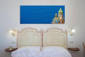 a bedroom with a bed and a picture on the wall at CASA OLGA, UN AFFACCIO SUL MARE !! in Praiano