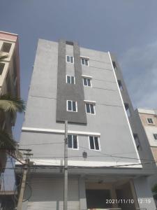 un edificio alto y blanco con ventanas laterales. en Dpinn homestay, en Hyderabad