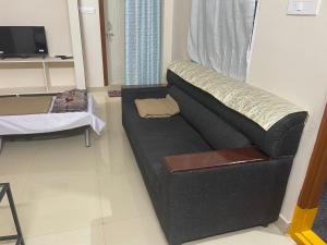 a black couch in a living room with a tv at Dpinn homestay in Hyderabad