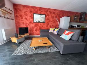 a living room with a couch and a table at Maison Duplex T4 6 couchages in Gujan-Mestras