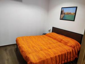 Un dormitorio con una cama con una manta naranja. en New Malù apartment, en Bari