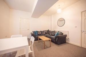 a living room with a couch and a table at Pottery House by YourStays in Stoke on Trent