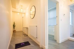 a hallway with a mirror and a mat on the floor at Pottery House by YourStays in Stoke on Trent