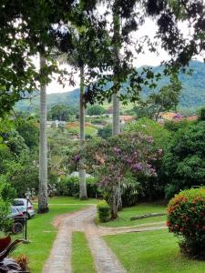 uma estrada de terra num parque com árvores e flores em Sítio Canto a Canto em Miguel Pereira