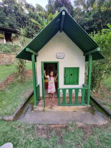 a girl standing in the doorway of a small house at Sítio Canto a Canto in Miguel Pereira