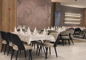 una sala da pranzo con tavoli e sedie con tovaglioli bianchi di Hotel Suljovic a Sarajevo