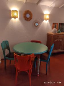 uma sala de jantar com uma mesa verde e cadeiras em La sauvagine em Saintes-Maries-de-la-Mer
