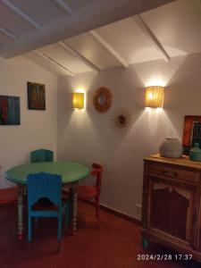 Habitación con mesa verde y 2 sillas en La sauvagine en Saintes-Maries-de-la-Mer