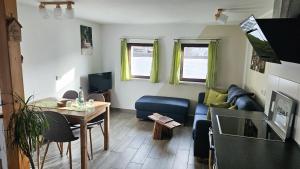 een woonkamer met een blauwe bank en een tafel bij Ferienhaus Balkenkunst in Radebeul
