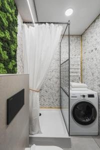 a washing machine in a bathroom with a curtain at City Center Apartment with balcony in Anykščiai