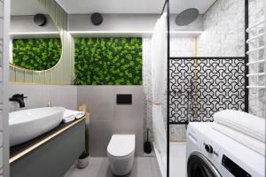 a bathroom with a sink and a washing machine at City Center Apartment with balcony in Anykščiai +16 photos