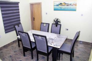 een eetkamer met een tafel en vier stoelen bij Cozy Urban Oasis 3 Bedroom in Ogba, Ikeja, Lagos in Egba