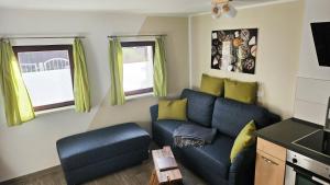 uma sala de estar com um sofá azul e almofadas amarelas em Ferienhaus Balkenkunst em Radebeul