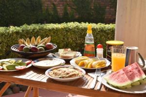 una mesa de madera con platos de comida y bebida en Room in BB - Amahoro Guest House - Queen Room en Ruhengeri