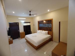 a bedroom with a large bed in a room at MADAVATH RESIDENCY in Kenichira