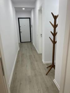a hallway with white walls and wooden floors and a door at Melody Apartment in Korçë in Korçë
