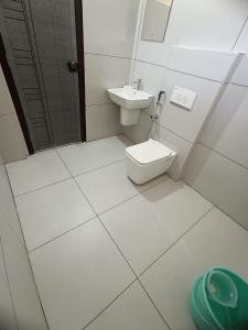 a white bathroom with a toilet and a sink at MADAVATH RESIDENCY in Kenichira