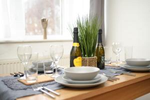 a table with two bottles of wine and plates and glasses at Cosy One Bedroom Apartment in London