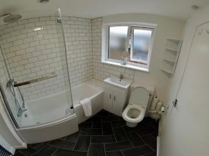 2-bed terraced home - 5 min walk to the City Walls في يورك: حمام مع حوض استحمام ومرحاض ودش